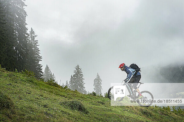 Man with Pedelec riding uphill in mountains  Saalfelden  Tyrol  Austria