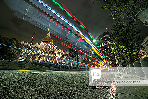 Long exposure bus lights passing in front of State House building.