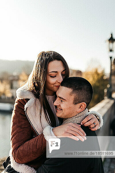 happy woman hugged her husband against the river in autumn