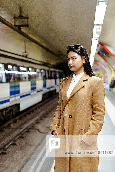 asian girl waiting for the subway on the platform