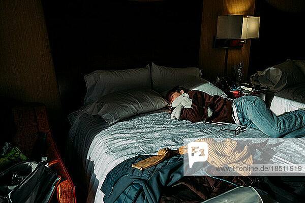 Teen girl sleeping on hotel bed during the day