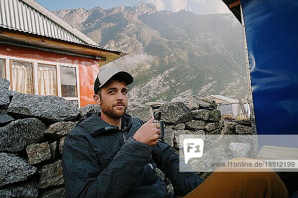 Young man sipping coffee in mountains