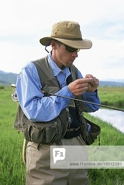 A fly-fisherman chooses an artificial fly.