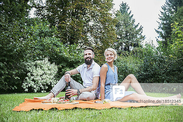 Young couple enjoying picnic in garden  Bavaria  Germany