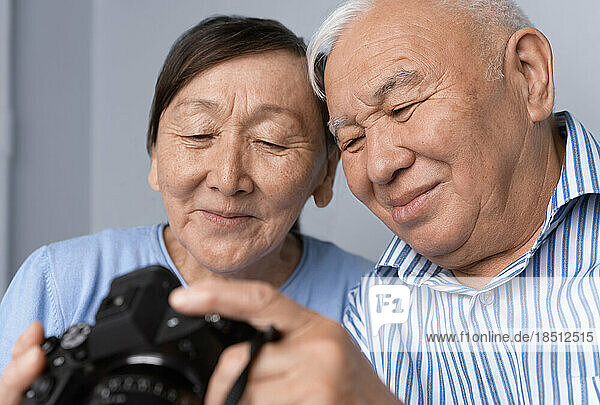 Senior couple enjoying digital camera photography at home