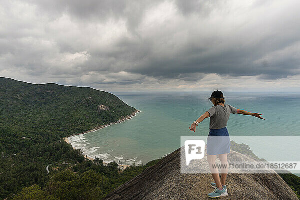 woman raising her arms on the bottle beach viewpoint.