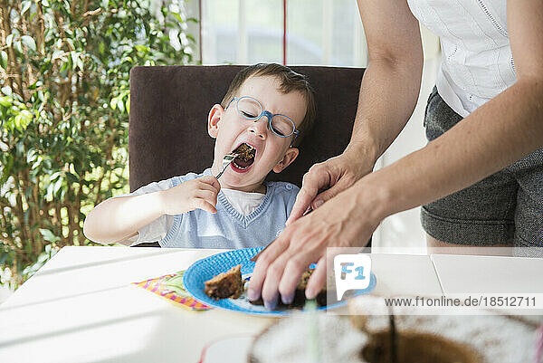 Mother and son having a slice of cake of birthday cake  Bavaria  Germany