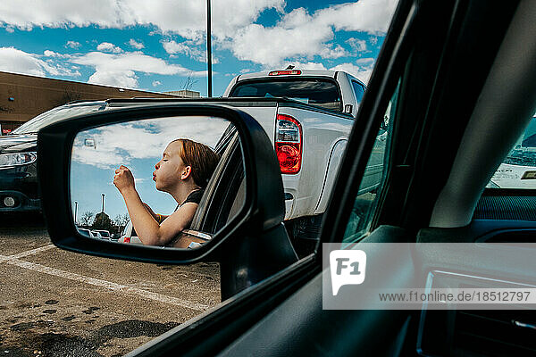 Tween girl blowing bubbles out of car window