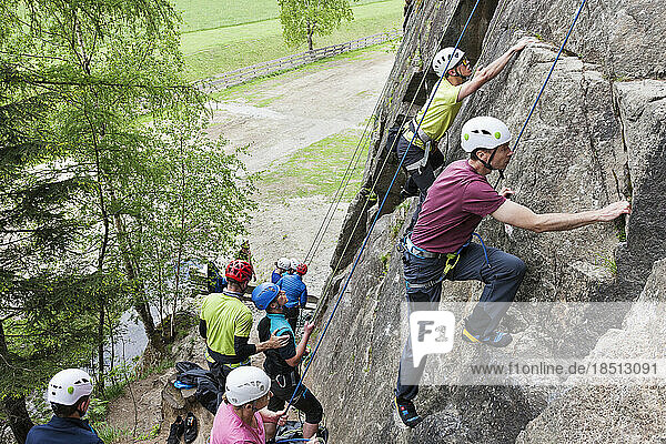 Group of rock climbers scaling a rock face at Oberried climbing garden  Otztal  Tyrol  Austria