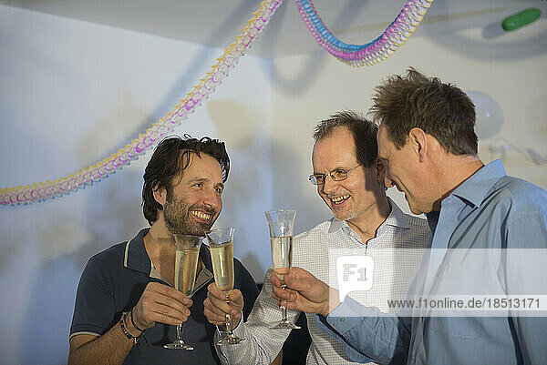 Men making celebratory toast with sparkling wine