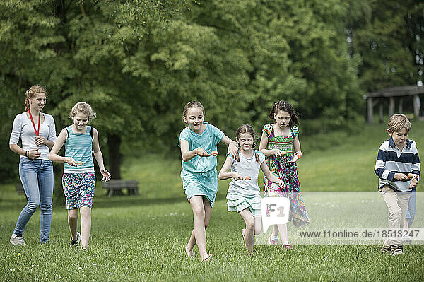 Group of children competing in an egg-and-spoon race in park  Munich  Bavaria  Germany