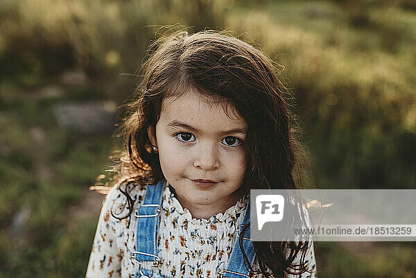 Serious portrait of young school-aged girl with sunlight in her hair