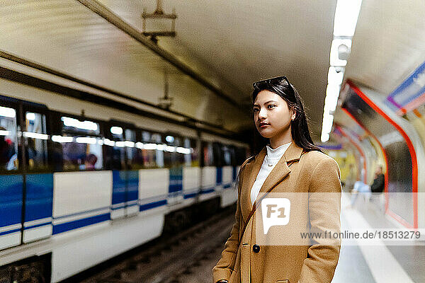 asian girl waiting for the subway on the platform