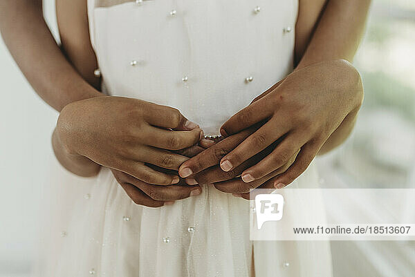 Close up of sisters' hands intertwined in studio