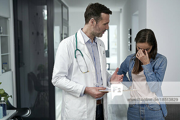 Gestresste Frau diskutiert mit Arzt in der Klinik