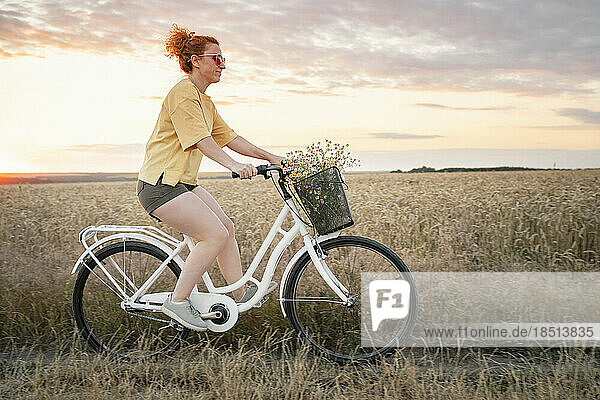 Frau fährt Fahrrad im Feld