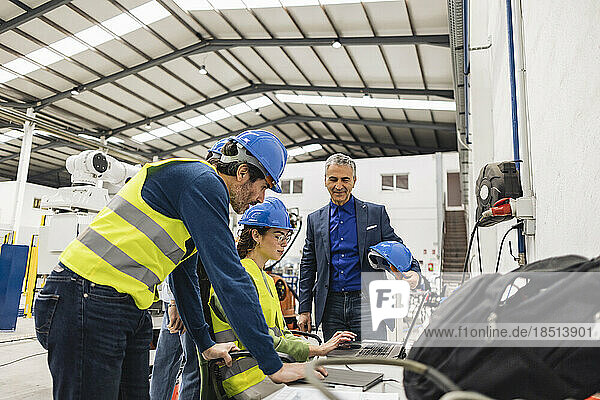 Ingenieure diskutieren am Laptop in der Fabrik