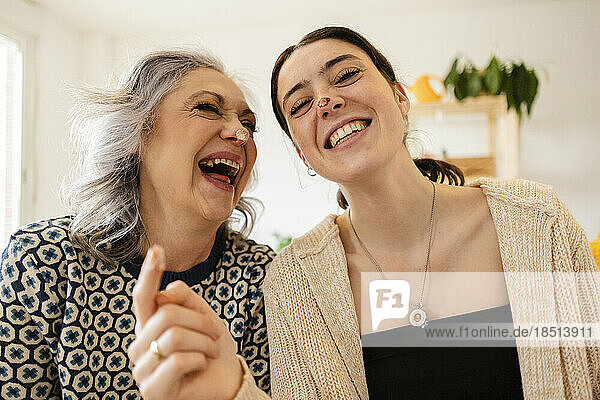 Happy mature woman with daughter having fun at home
