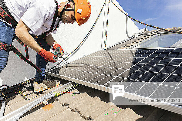 Young engineer with work tool installing solar panels