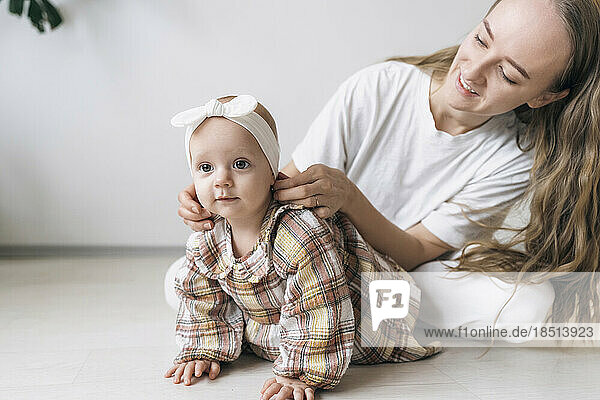 Lächelnde Mutter passt das Stirnband am Kopf ihrer Tochter an