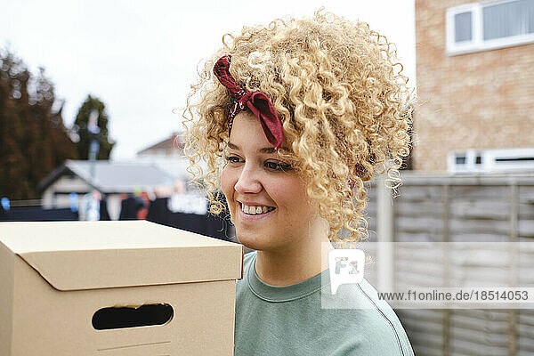 Lächelnde junge Frau mit Karton