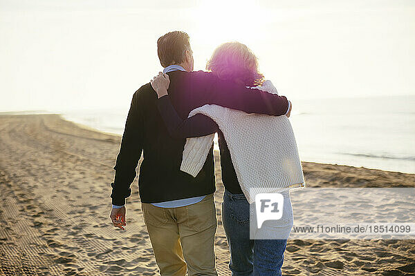 Liebevolles älteres Paar  das gemeinsam am Strand spaziert