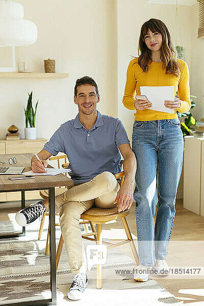 Freelancing couple with document at home office