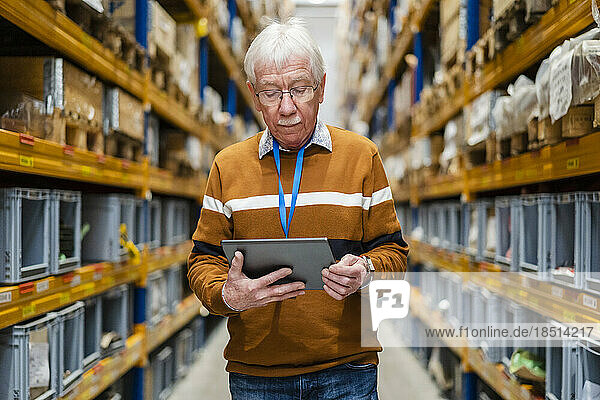 Senior man using tablet PC at warehouse
