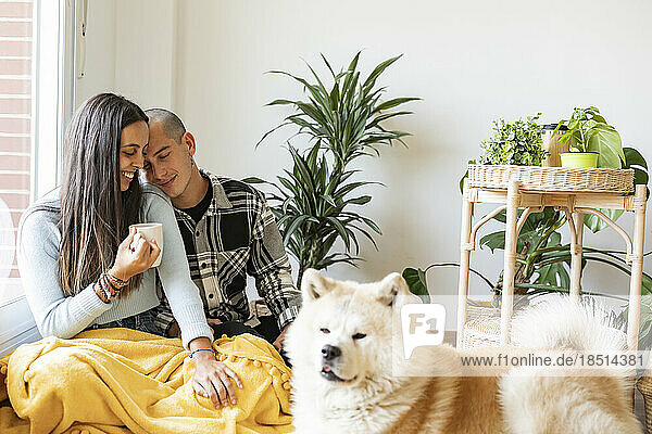 Liebevolles Paar beim Kaffeetrinken mit Hund im Vordergrund
