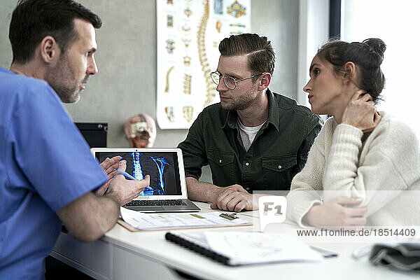Doctor having discussion with couple over medical x-ray