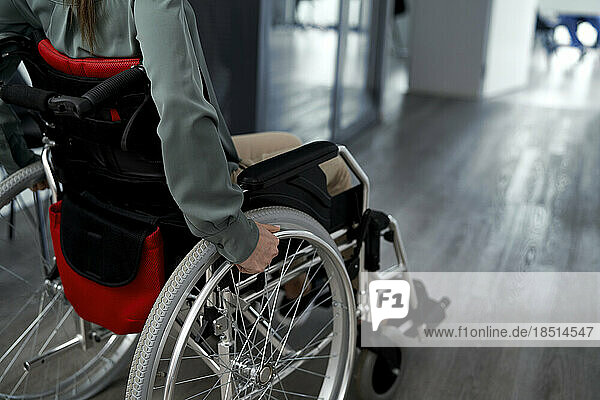 Frau mit Behinderung sitzt im Rollstuhl in der Klinik