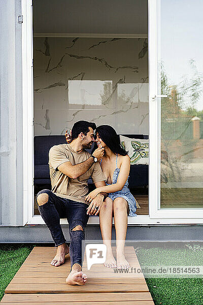Romantic couple enjoying together sitting outside container home