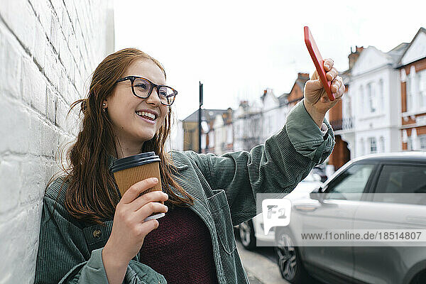 Glückliche junge Frau  die ein Selfie mit dem Smartphone macht