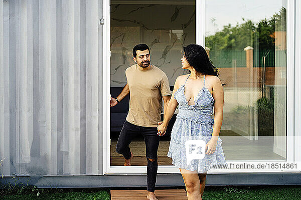 Boyfriend and girlfriend walking out of container home