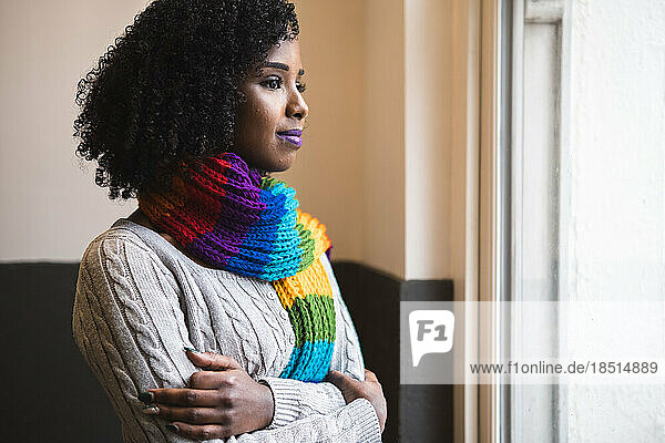 Woman wearing multi colored scarf looking out of window