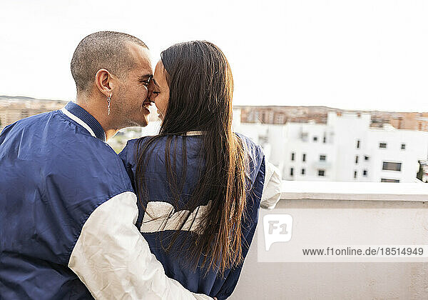 Romantic couple rubbing noses on balcony