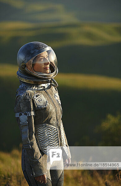 Thoughtful woman wearing space costume and helmet