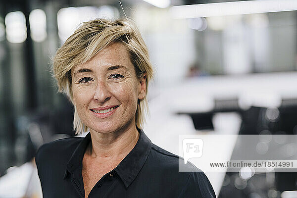 Smiling businesswoman with blond hair in office