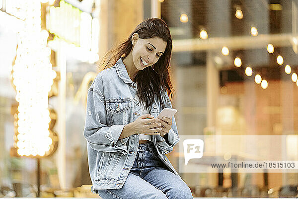 Happy young woman using smart phone
