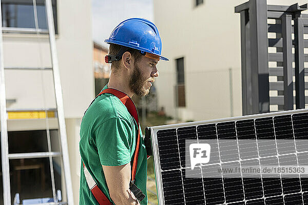 Techniker hält Solarpanel an sonnigem Tag