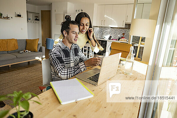 Couple having discussion over laptop at home office