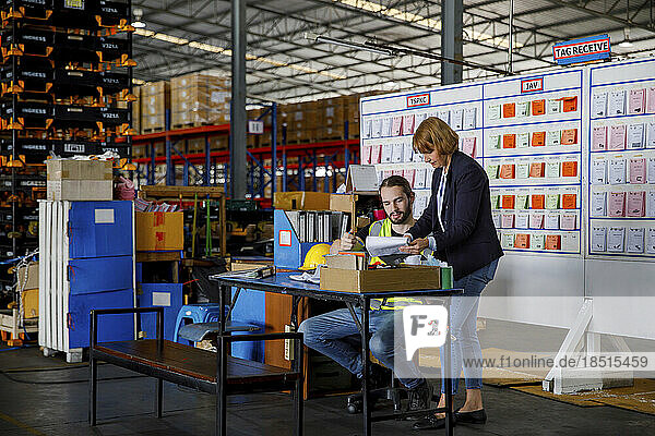 Manger and colleague working at warehouse