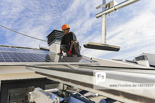 Engineer installing solar panels under cloudy sky