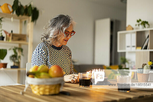 Smiling mature woman celebrating birthday at home