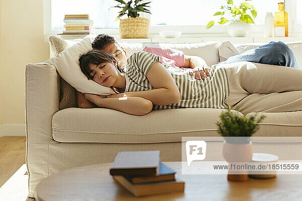Woman and boyfriend sleeping on sofa at home