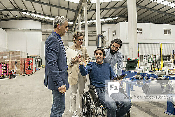 Disabled engineer having discussion with colleagues in industry