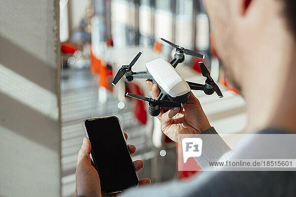 Businessman with mobile phone and drone at office