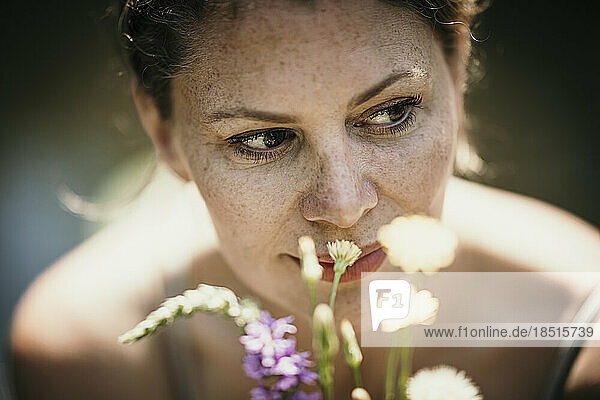 Thoughtful mature woman by flowers