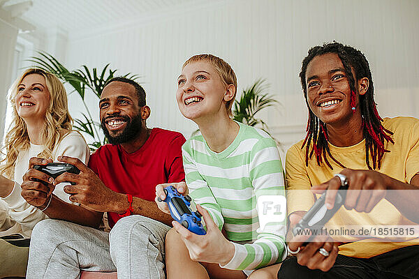 Young men and woman playing video game with friend at home