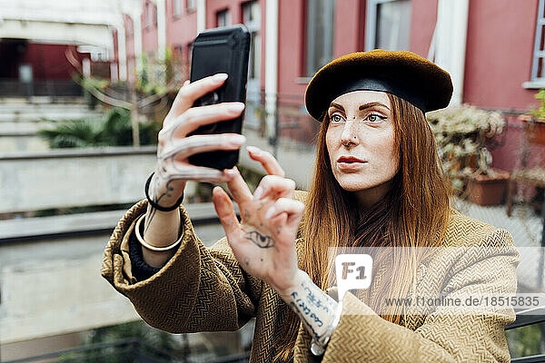 Redhead woman taking selfie through smart phone